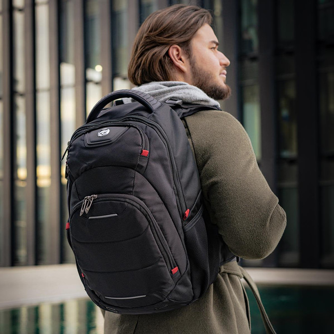 A black Swissdigital Neptune backpack featuring multiple pockets and a sleek design, held by a person outdoors.