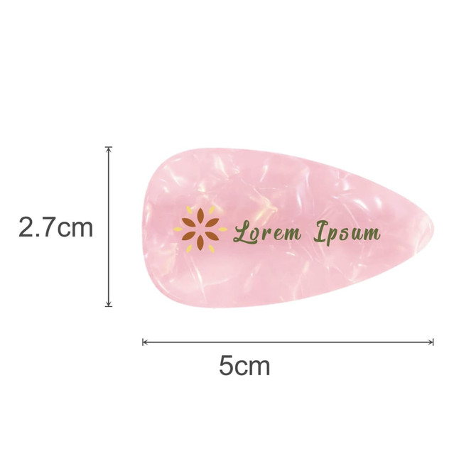 A teardrop-shaped, iridescent hair clip in pink and gold with a logo, measuring 5 cm by 2.7 cm.