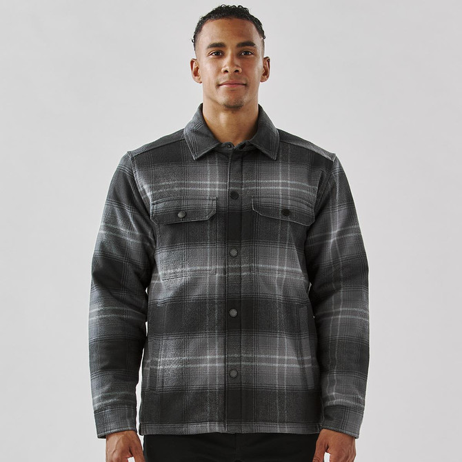 A men's black and grey plaid jacket featuring a Sherpa lining and front pockets, with a branded logo.