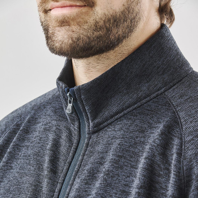 A grey full zip fleece jacket with a stand-up collar, featuring a branding logo and a textured fabric.