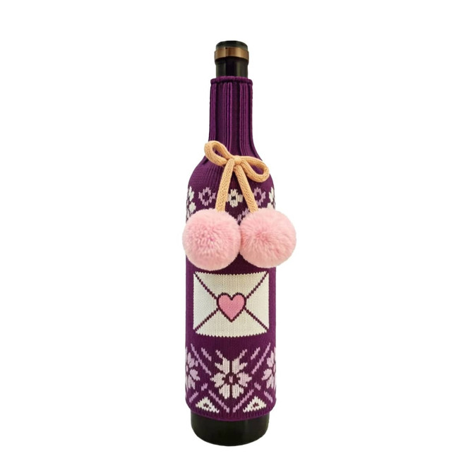 A drink bottle inside a purple custom knitted sleeve, featuring pink pom-poms and a heart design.