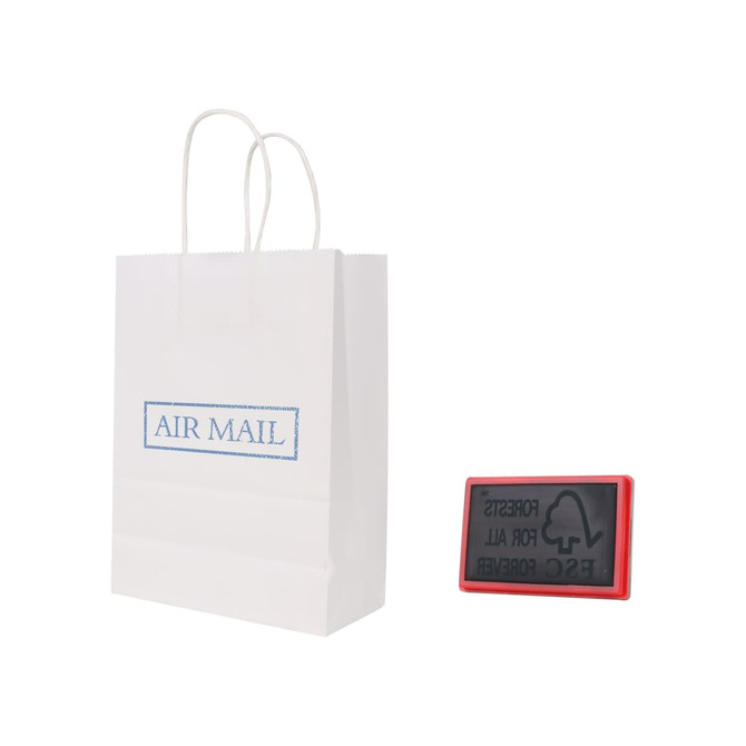 A white kraft paper bag with twisted handles beside a red rubber stamp. The bag features a branding logo.