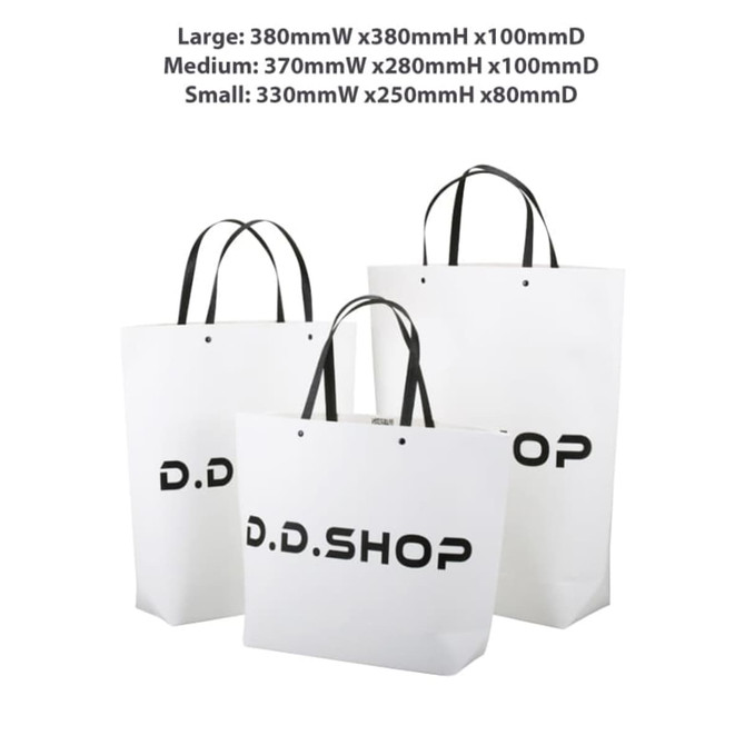 Three white paper bags of varying sizes with black handles, featuring a logo on each. The medium bag measures 370 x 280 x 100mm.