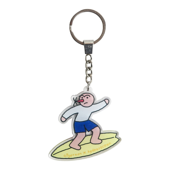 A custom-shaped acrylic keyring featuring a cartoon figure surfing, with a silver keychain and multicoloured design.