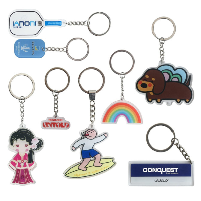 A variety of custom shape acrylic keyrings in vibrant colours, featuring unique designs and a logo on one.