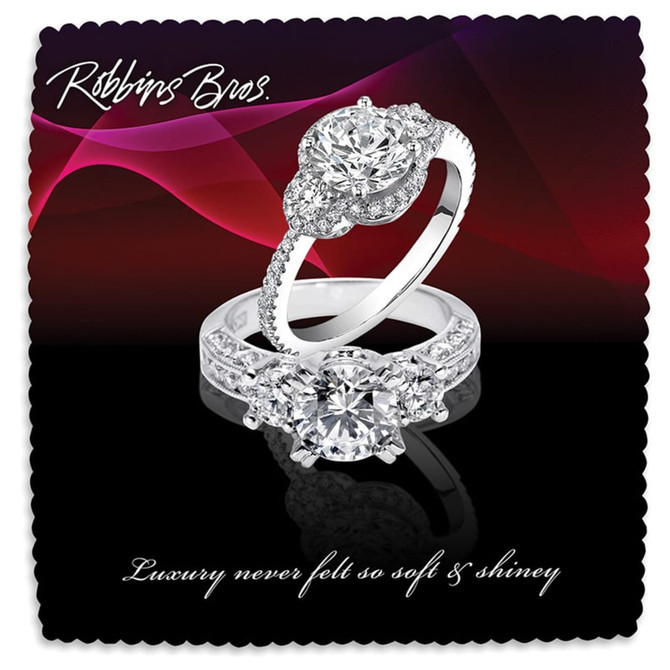 A pair of elegant rings featuring large diamonds and intricate detailing, displayed on a dark, wavy background.