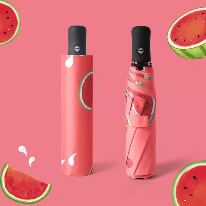 A pink watermelon-themed umbrella with a matching sleeve, featuring vibrant green and red watermelon designs.