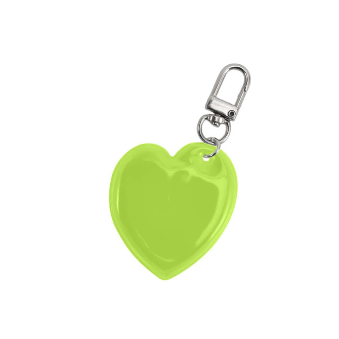 A heart-shaped reflective keychain in bright lime green with a metal clip.