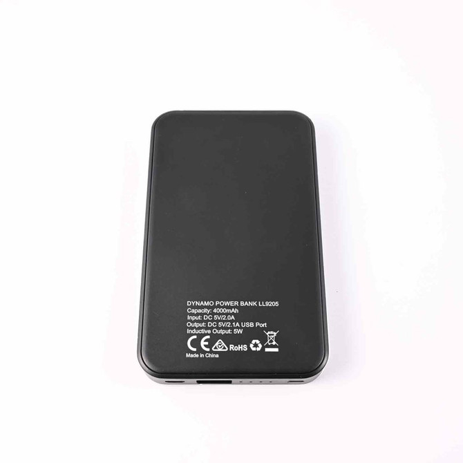 A black Dynamo Wireless Power Bank with specifications printed on the back, including input and output details.