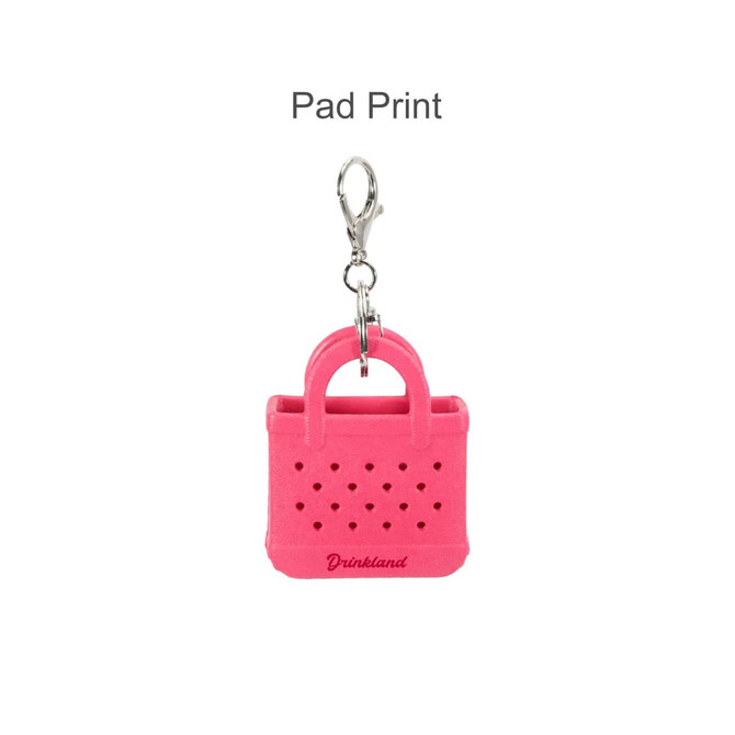 A pink mini EVA holes bag keychain with a silver clip, featuring a simple handbag design and branding.