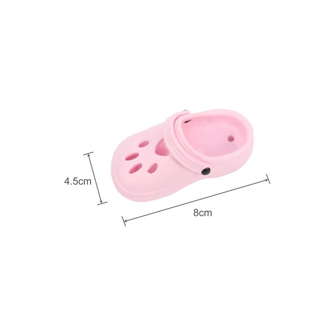 A pink clog shoe-shaped charm with ventilation holes, measuring 8 cm by 4.5 cm, features a branding logo.