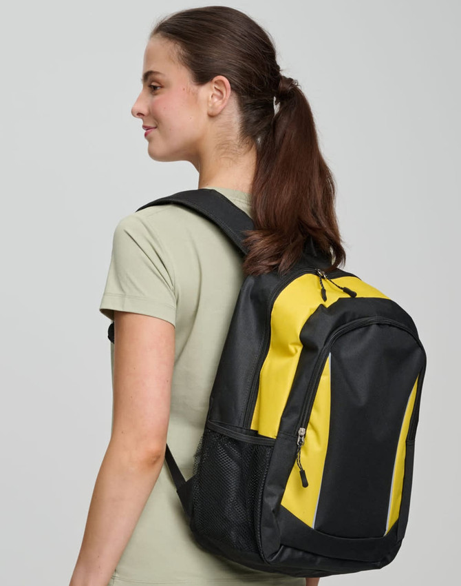 A black and yellow backpack with a logo, worn over one shoulder by a woman with long brown hair.