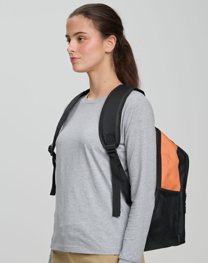 A person wearing a grey long-sleeve shirt carries a black and orange backpack with shoulder straps.