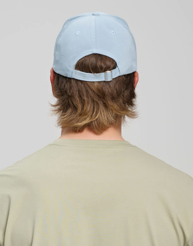 A light blue Jacquard Texture 5 Panel Cap seen from the back, featuring an adjustable strap and a logo.