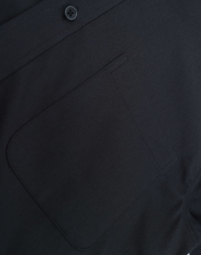 A black cotton blend long-sleeve shirt featuring a chest pocket and button detail. It also has a logo.