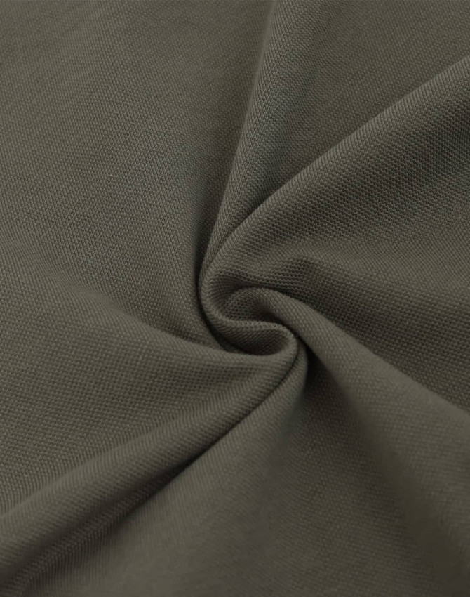 A close-up of dark olive green fabric with a soft texture, featuring a pique weave pattern.