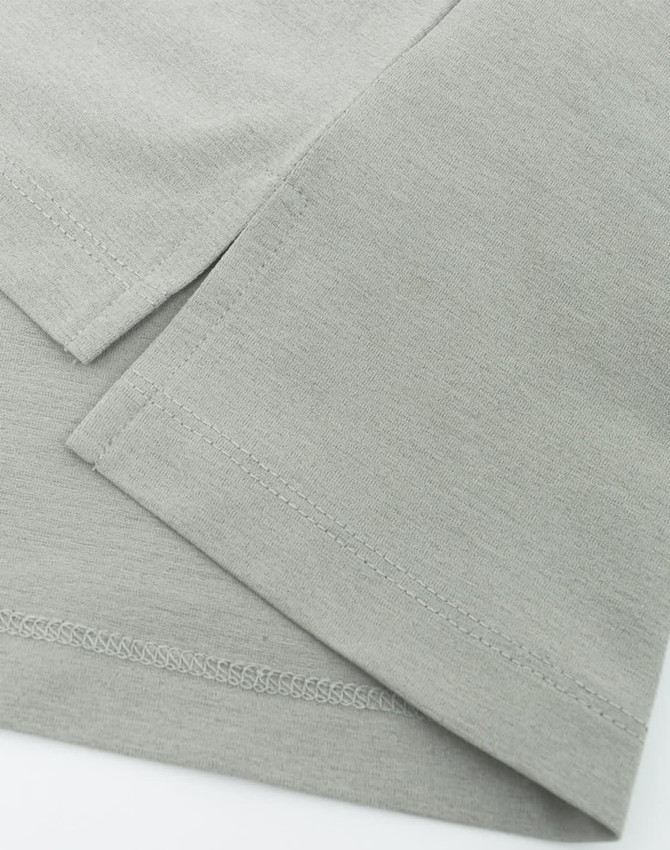 A close-up of a grey high-performance polo shirt, highlighting the fabric texture and neatly stitched hems.