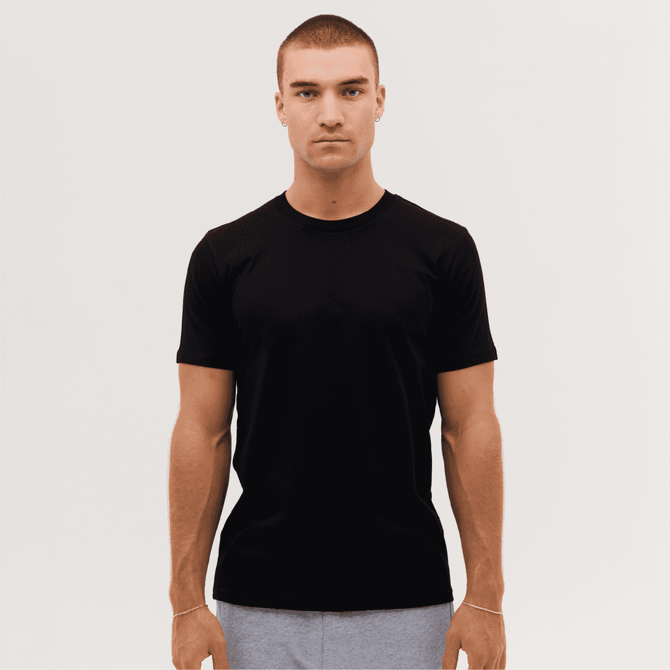 A plain black classic tee displayed on a model with short sleeves and a crew neck.