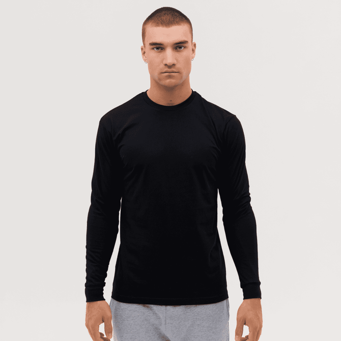 A long sleeve tee in black, featuring a fitted design and a logo, worn by a model against a plain background.