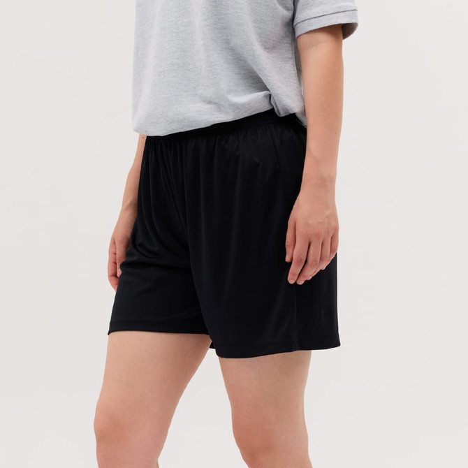A pair of black shorts with an elastic waistband, modelled by a person wearing a grey shirt.