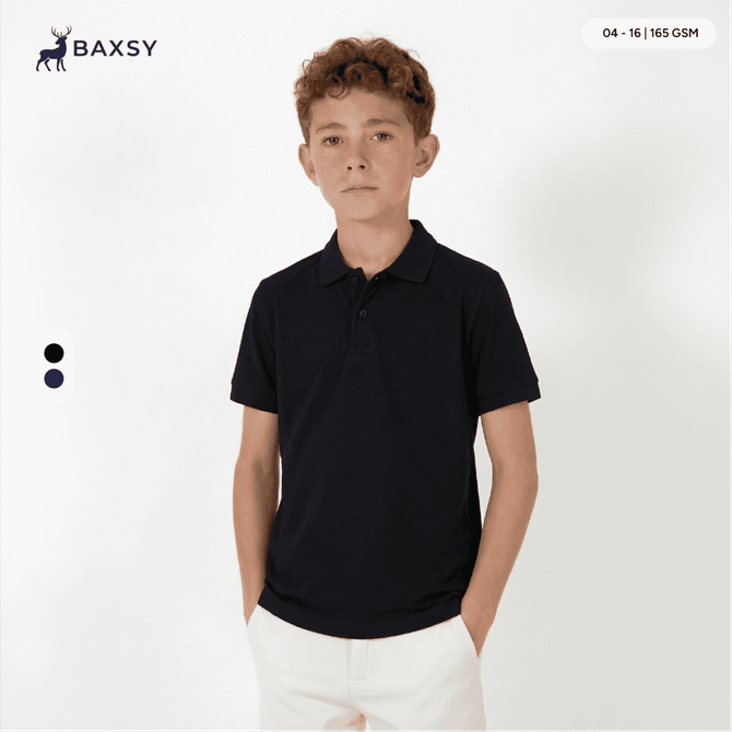 A black youth polo shirt with a collar, displayed on a model against a plain background. Features a logo.