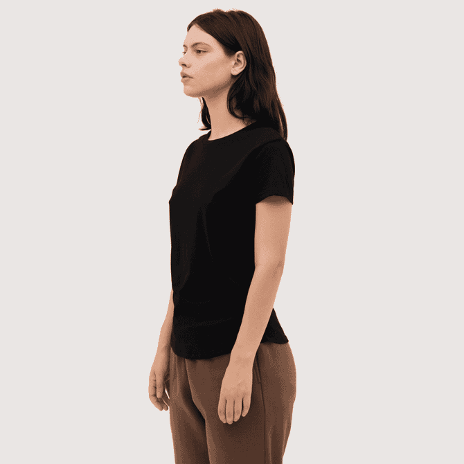 A black women's essential tee is displayed on a model, showcasing a simple, fitted design.