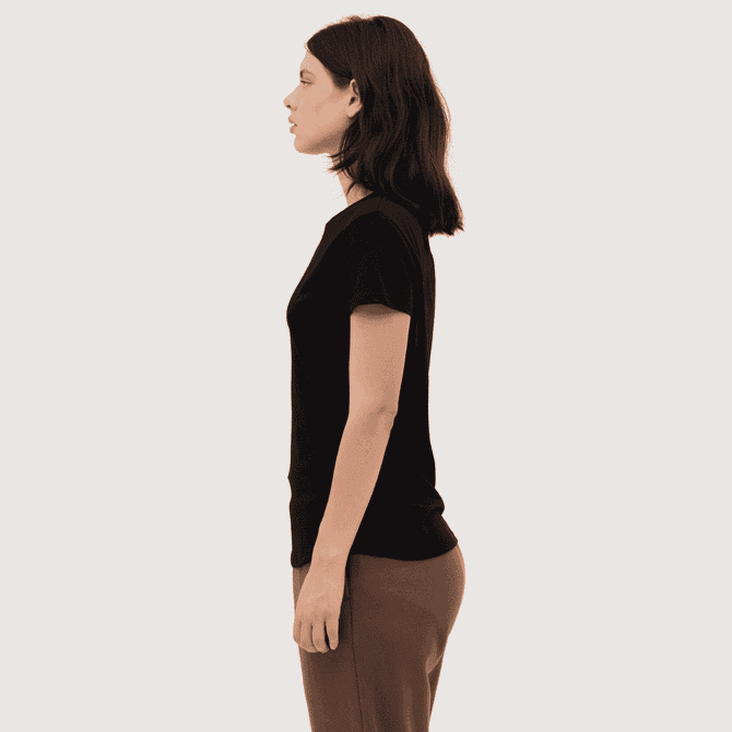 A women's essential tee in black, featuring a fitted design and short sleeves, displayed on a model from the side.