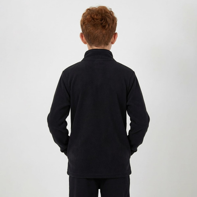 A child wearing a black polar fleece 1/4 zip top, viewed from the back with hands in pockets.