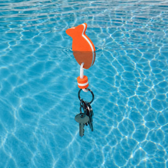 An orange fish-shaped EVA floating keychain with keys attached, floating on the surface of a blue pool.