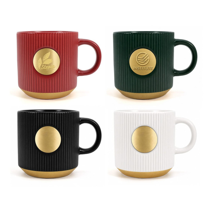 A set of four ceramic coffee mugs in red, green, black, and white, each with a gold medal on the base and a logo.
