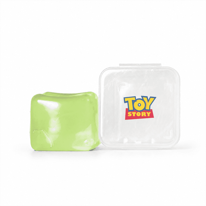 A green jelly cube sensory toy next to a clear container featuring a logo.