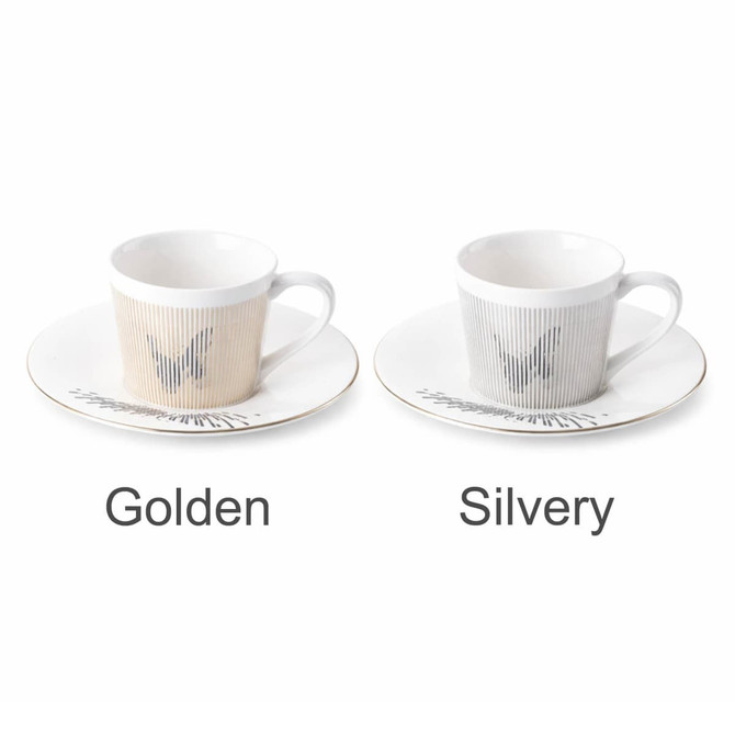 A coffee mug set featuring a golden and a silvery mug with corresponding saucers, both with a decorative design.