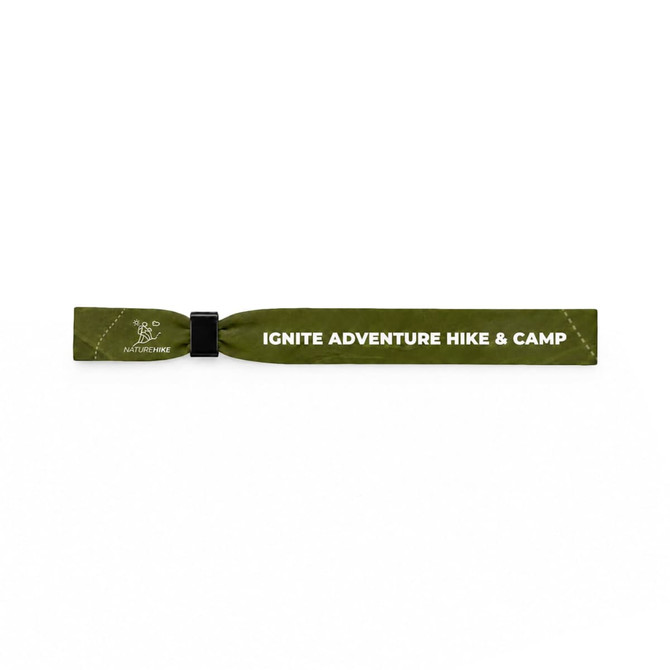 A green wristband with a logo and text detailing an adventure hiking and camping theme.