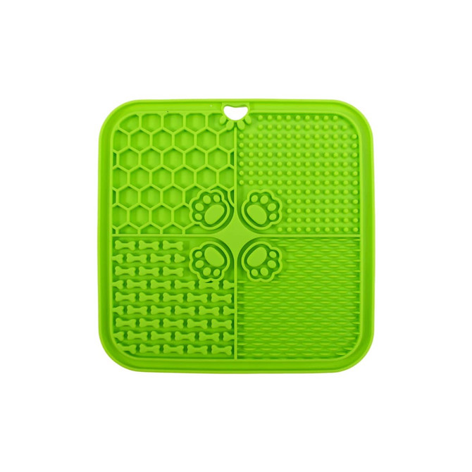 A green, four-section dog enrichment lick mat featuring various textured patterns, including bones and paw prints.