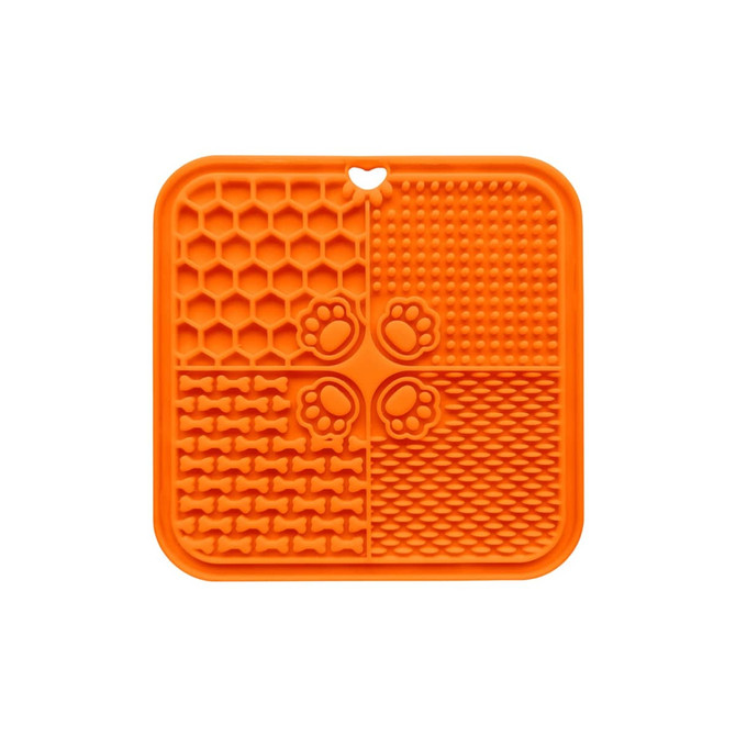 An orange, four-section silicone lick mat with various textures, including paw prints and bone shapes.