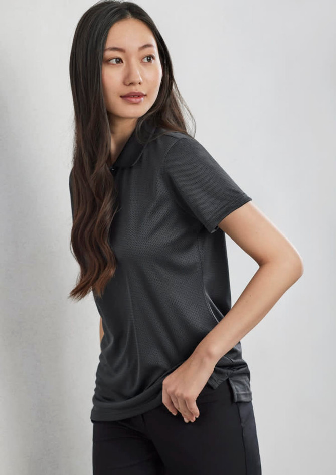 A woman wearing a black short sleeve polo shirt, featuring a collar and a logo on the side.