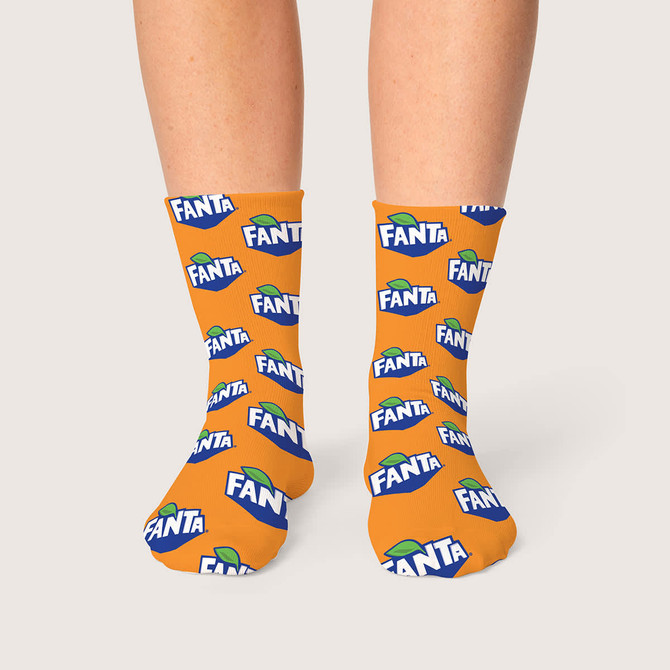 Bright orange socks with repeated Fanta branding, featuring a logo and green leaf design.