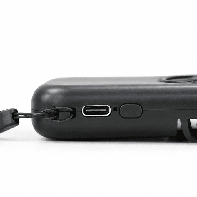 A black mini pocket fan with a USB-C charging port and a strap attachment for easy carrying.