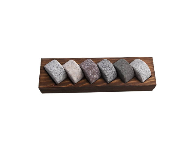 A wooden base holds six whisky discs in varying shades of grey and stone, designed for cooling drinks.