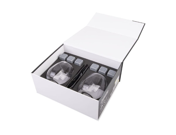A white box containing two gin glasses, grey chilling stones, and a stirring spoon. Includes a logo on the box.