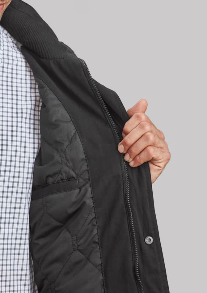 A black jacket with a zip and quilted lining, partially opened to reveal the interior. It features a logo.