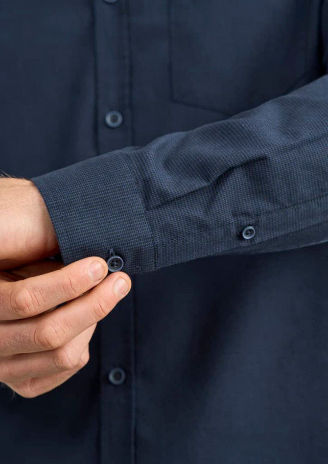 A dark blue long sleeve button-up shirt with a textured cuff and a small pocket on the chest.