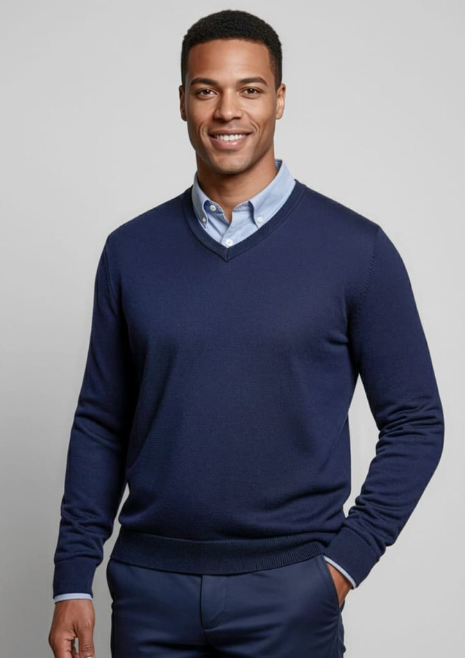 A navy knitted jumper with a V-neck and fitted cuffs, worn over a light blue collared shirt. Features a logo.