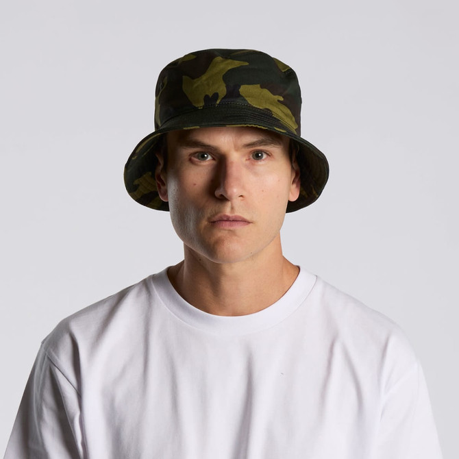 A camo bucket hat in green and black, featuring a wide brim and a fitted design. It includes a branding logo.