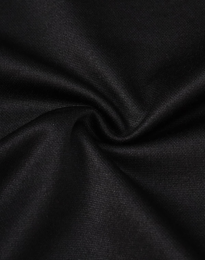 A close-up view of black sustainable poly/cotton fabric with a smooth texture and slight stretch.