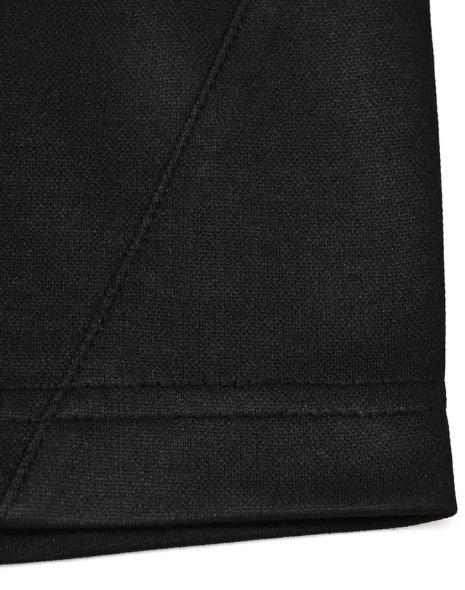 A close-up of a black sustainable poly/cotton polo shirt showing the hem and stitching details. Features a logo.