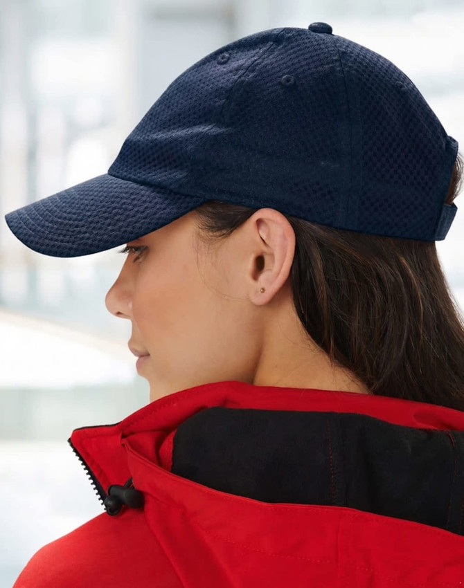 A navy athletic mesh cap is displayed, featuring a rounded peak and an adjustable strap at the back.
