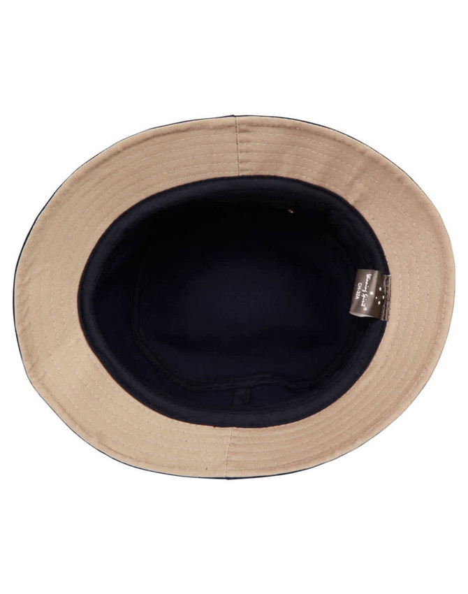 A bucket hat with a navy interior and a light beige exterior, featuring a logo inside.