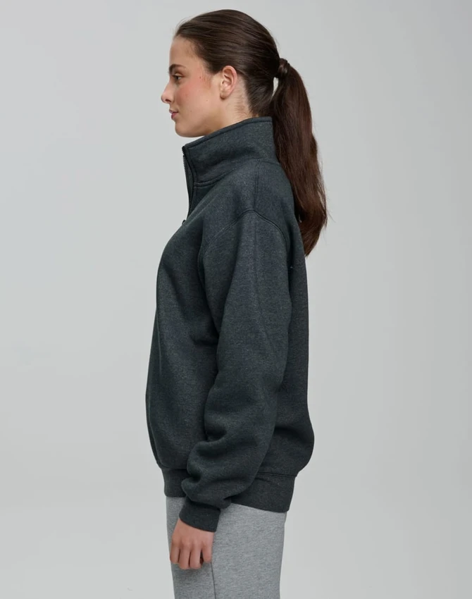 A grey 1/2 zip collar fleecy jumper displayed on a model from the side, featuring a smooth fabric and a logo.