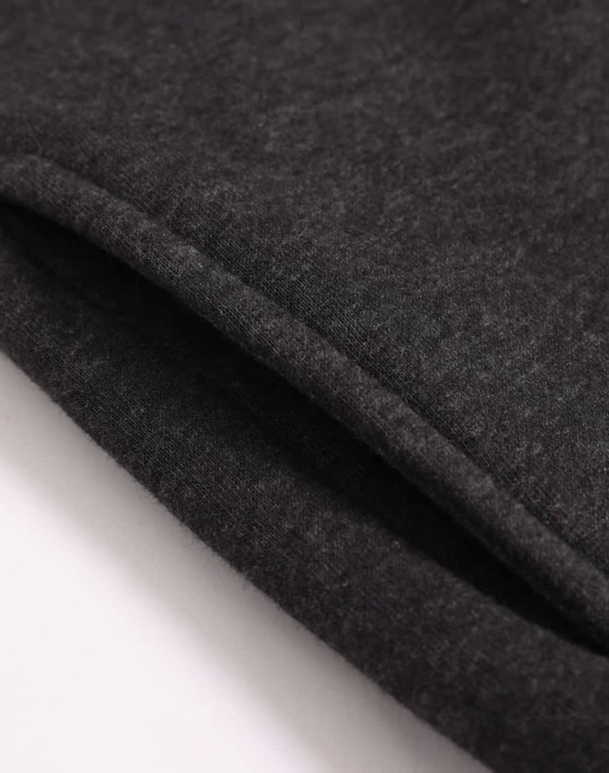 A close-up of a dark grey 1/2 zip collar fleecy jumper, showing the soft texture and stitching details.